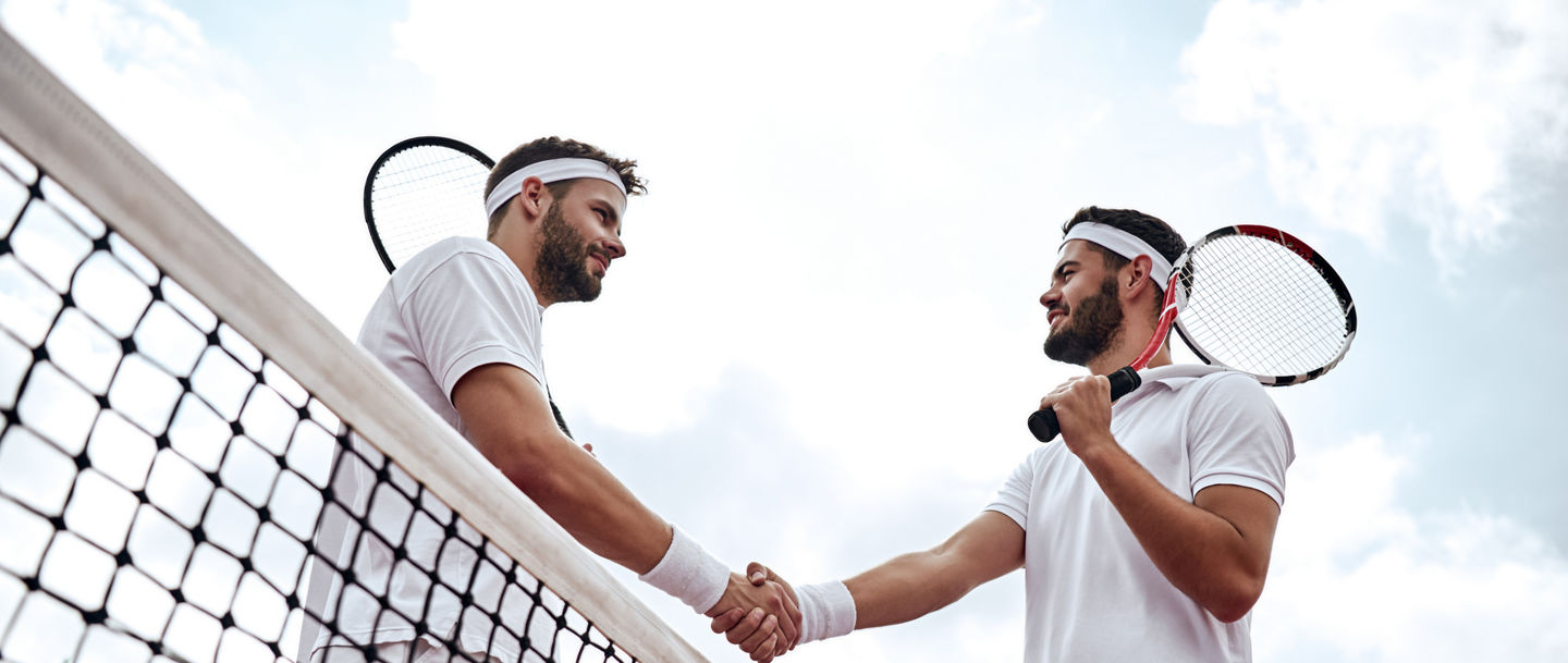 Respect your opponent. Tennis players after the match, Two handsome tennis players shake hands on the court after the match