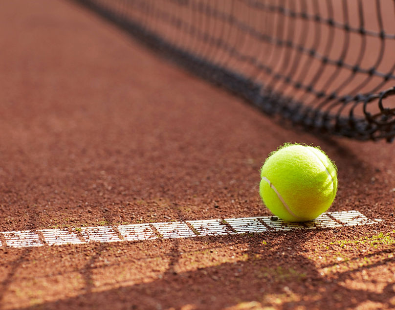 Tennis, ball and clay court, net and line for exercise, training and fitness outdoor in summer. Sports, netting and closeup of sphere on ground for game, competition and workout on field and pitch. model released / property released Copyright: xPeopleImages.comx-x 51aba3c15c5d3x