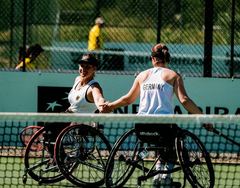 Krüger und Wend klatschen im Rollstuhltennisdoppel ab