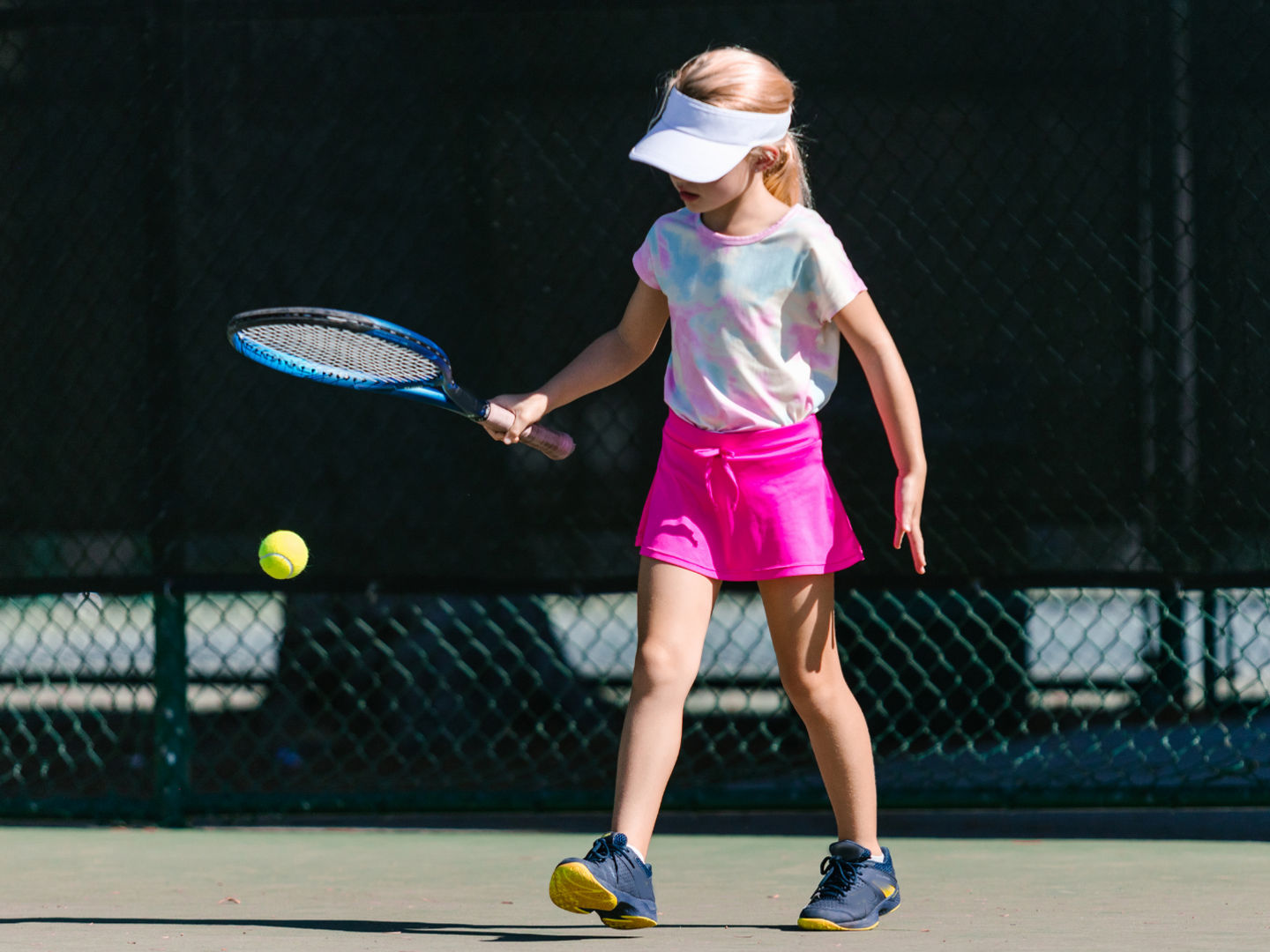 Young girl playing tennis outdoors