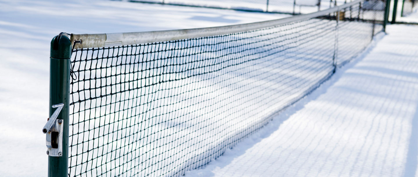 Snow-covered tennis court with net