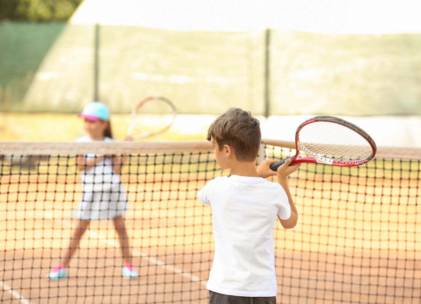 zwei Kinder spielen Tennis